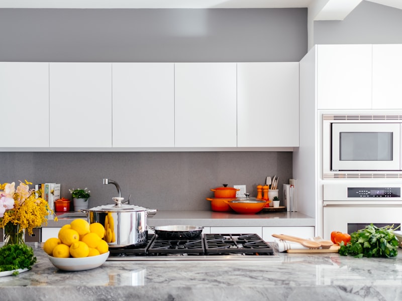A spotless modern kitchen with white cabinets and a clean stovetop